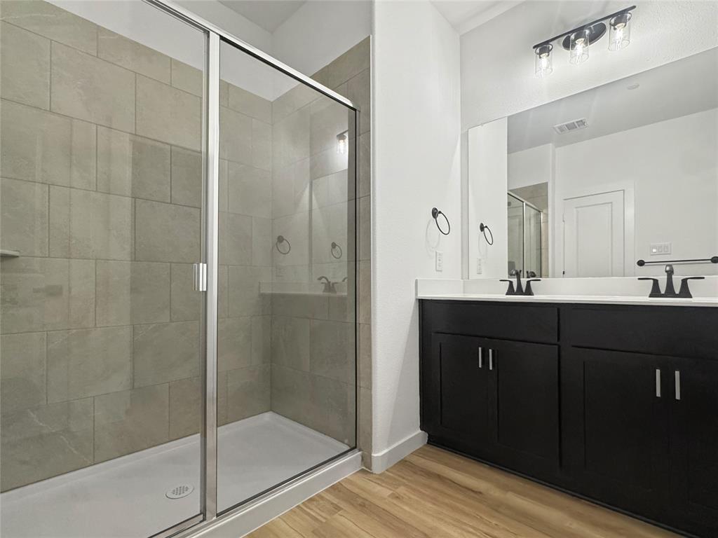 1614 Governors Boulevard Heath, TX 75126 - Photo 34 of 37 a bathroom with a glass door shower a sink and a mirror