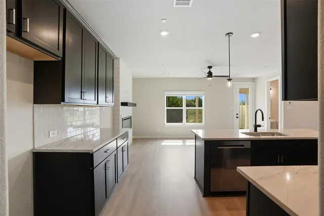a kitchen with stainless steel appliances kitchen island granite countertop a sink and cabinets