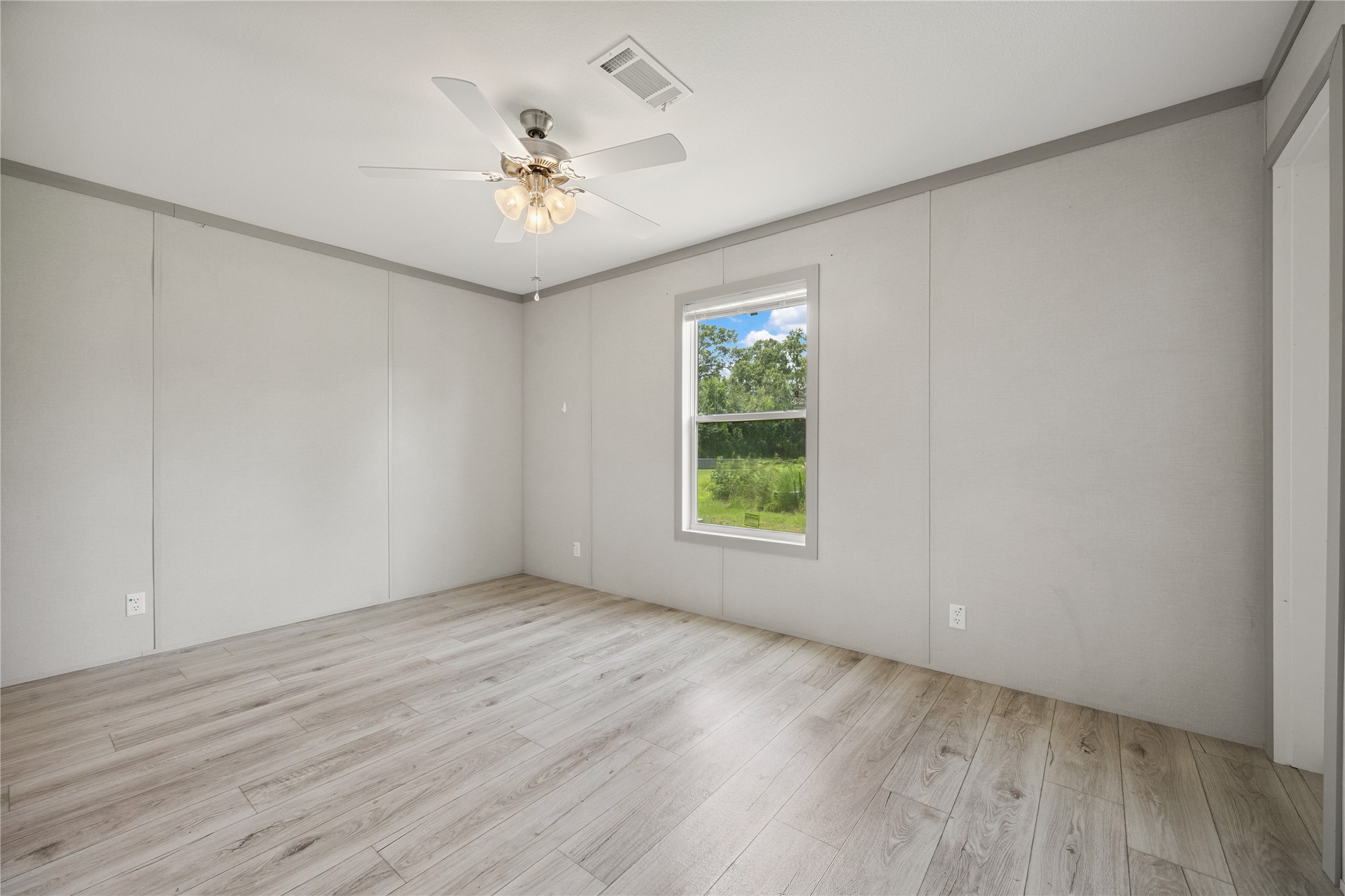 3006 County Road 2068 Hull, TX 77564 - Photo 20 of 27 an empty room with wooden floor chandelier fan and windows