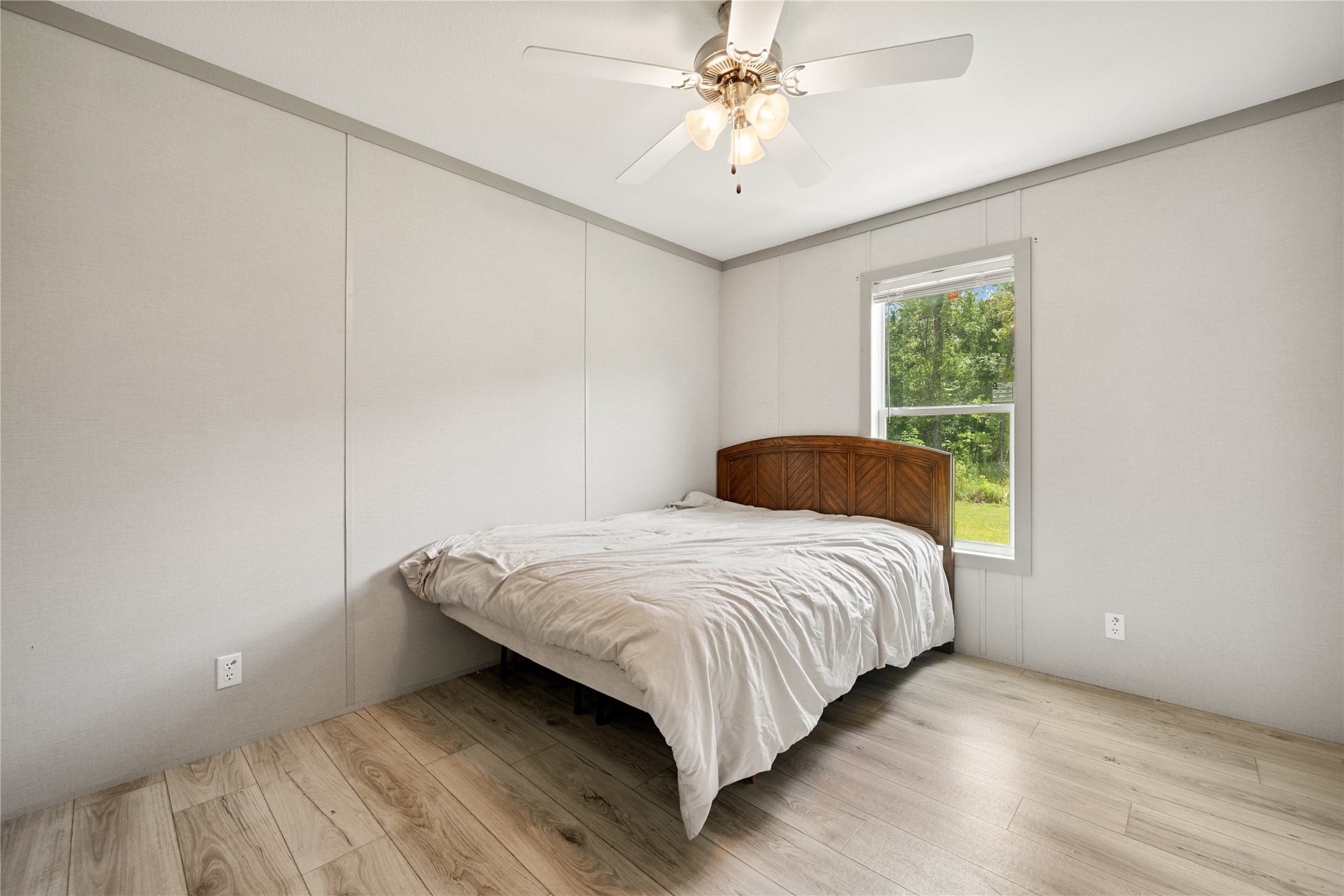 3006 County Road 2068 Hull, TX 77564 - Photo 23 of 27 a bedroom with a bed and wooden floor