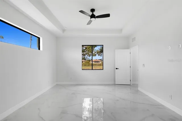 an empty room with windows and fan