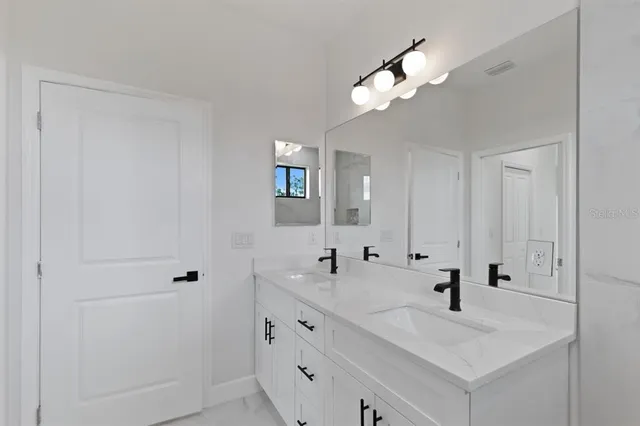 a bathroom with a sink vanity and mirror