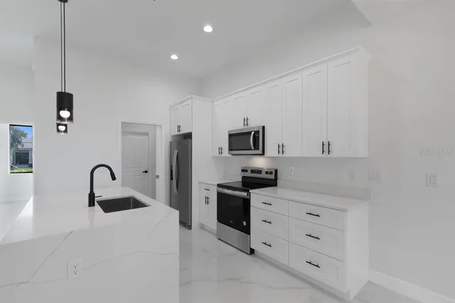 a kitchen with white cabinets and stainless steel appliances