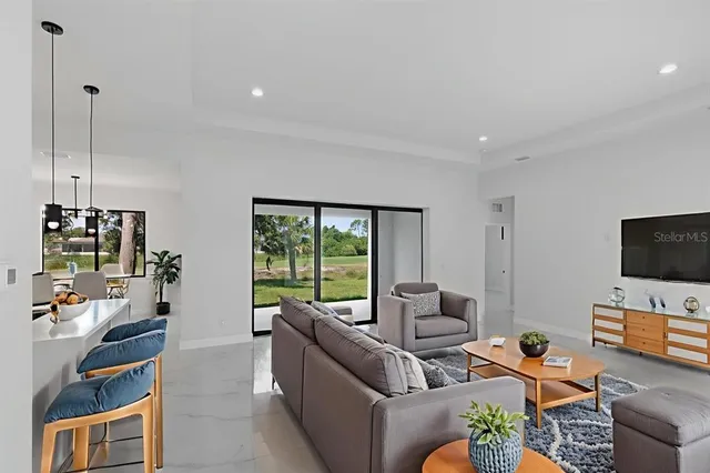 a living room with furniture a flat screen tv and a large window