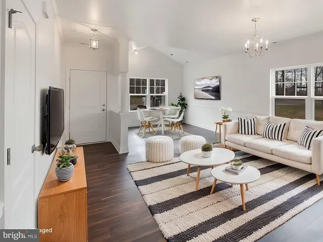 a living room with furniture a rug and a flat screen tv