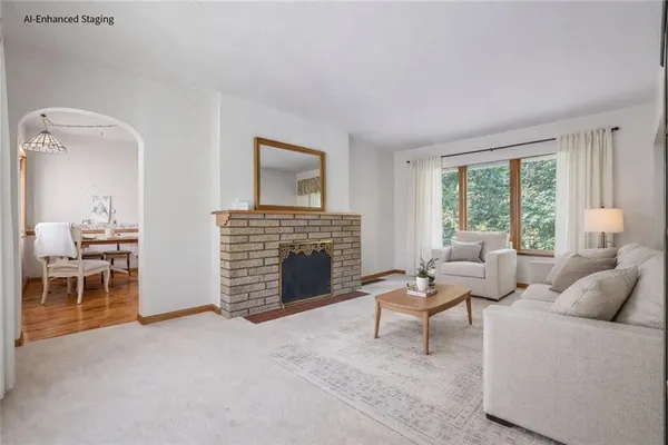 a living room with furniture a fireplace and a large window