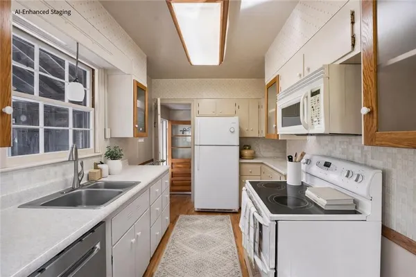 a kitchen that has a sink a stove and refrigerator