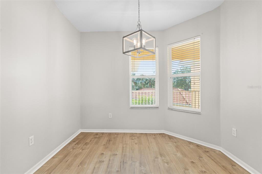 7187 Boca Grove Place, Unit 201 Lakewood Ranch, FL 34202 - Photo 12 of 48 an empty room with wooden floor and windows