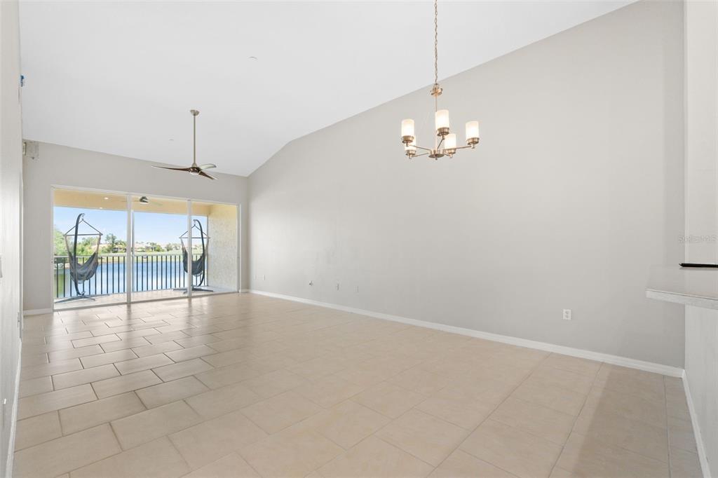 7187 Boca Grove Place, Unit 201 Lakewood Ranch, FL 34202 - Photo 13 of 48 an empty room with chandelier fan and windows