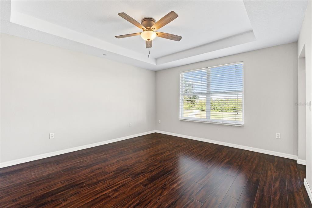 7187 Boca Grove Place, Unit 201 Lakewood Ranch, FL 34202 - Photo 17 of 48 an empty room with wooden floor and windows