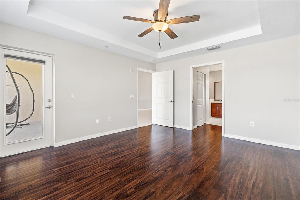 7187 Boca Grove Place, Unit 201 Lakewood Ranch, FL 34202 - Photo 18 of 48 an empty room with wooden floor and ceiling fan