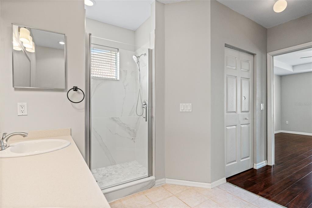 7187 Boca Grove Place, Unit 201 Lakewood Ranch, FL 34202 - Photo 21 of 48 a bathroom with a sink a toilet and shower