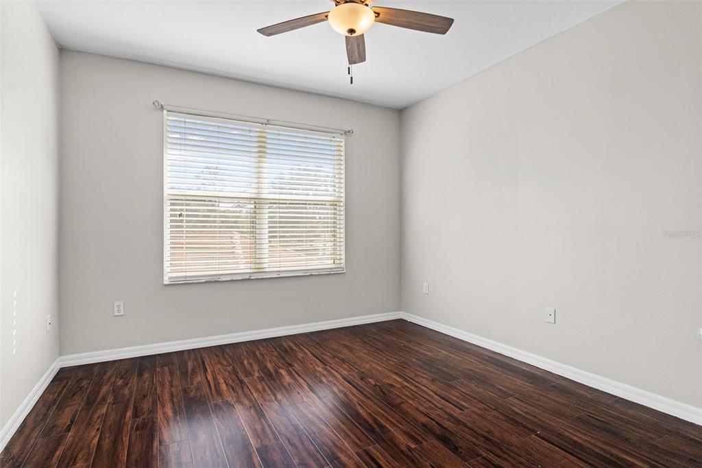 7187 Boca Grove Place, Unit 201 Lakewood Ranch, FL 34202 - Photo 25 of 48 a view of an empty room with wooden floor and a window