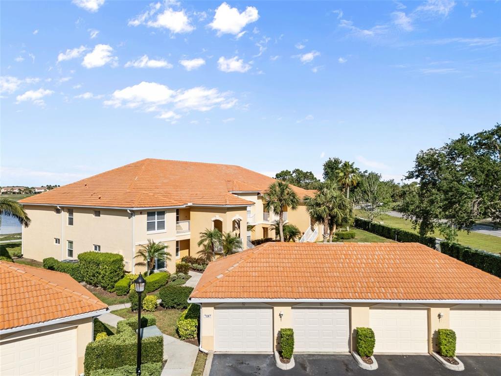 7187 Boca Grove Place, Unit 201 Lakewood Ranch, FL 34202 - Photo 34 of 48 a view of a white house with a yard table and chairs