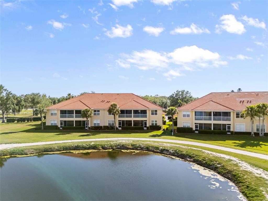 7187 Boca Grove Place, Unit 201 Lakewood Ranch, FL 34202 - Photo 38 of 48 a view of a house with a big yard and large trees