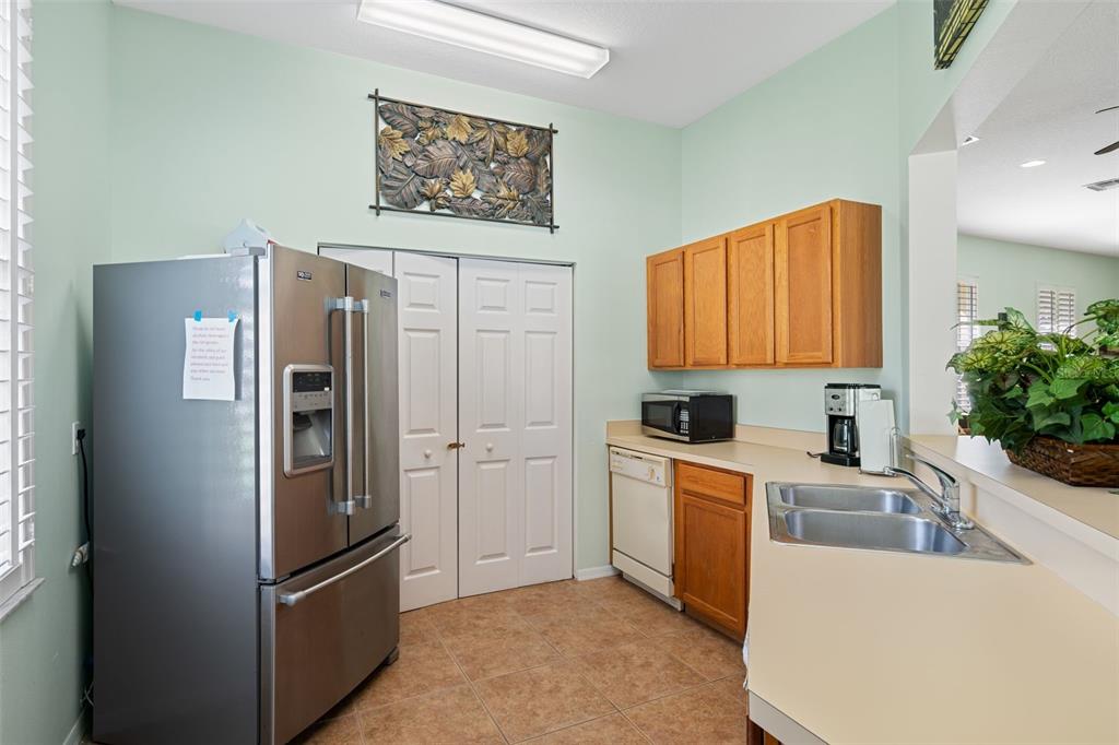 7187 Boca Grove Place, Unit 201 Lakewood Ranch, FL 34202 - Photo 46 of 48 a kitchen with stainless steel appliances granite countertop a refrigerator and a sink