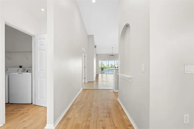 a view of a hallway with wooden floor and a bathroom