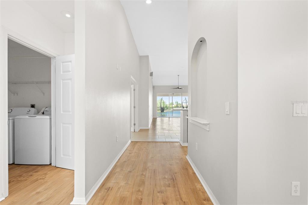 7187 Boca Grove Place, Unit 201 Lakewood Ranch, FL 34202 - Photo 5 of 48 a view of a hallway with wooden floor and a bathroom