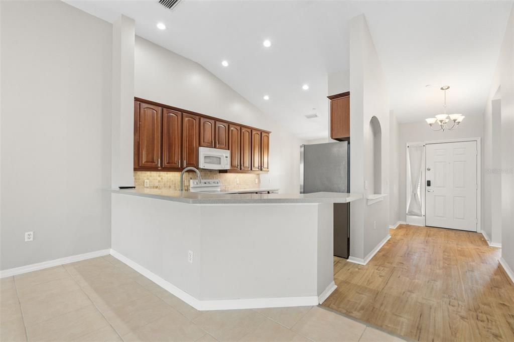 7187 Boca Grove Place, Unit 201 Lakewood Ranch, FL 34202 - Photo 7 of 48 a kitchen with stainless steel appliances a refrigerator and a stove top oven