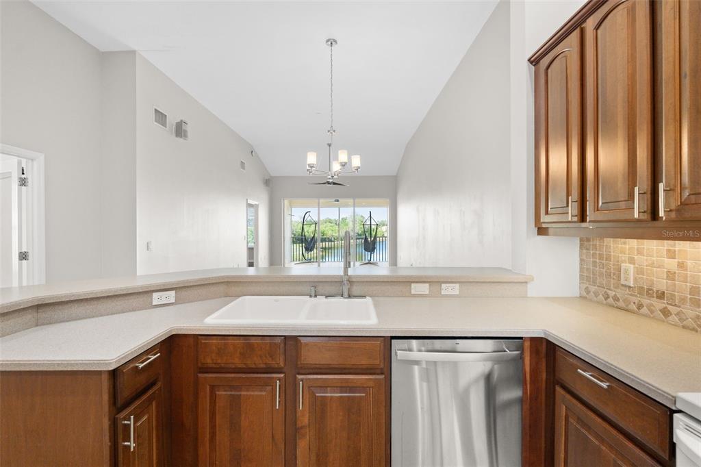 7187 Boca Grove Place, Unit 201 Lakewood Ranch, FL 34202 - Photo 10 of 48 a kitchen with a sink stove and cabinets