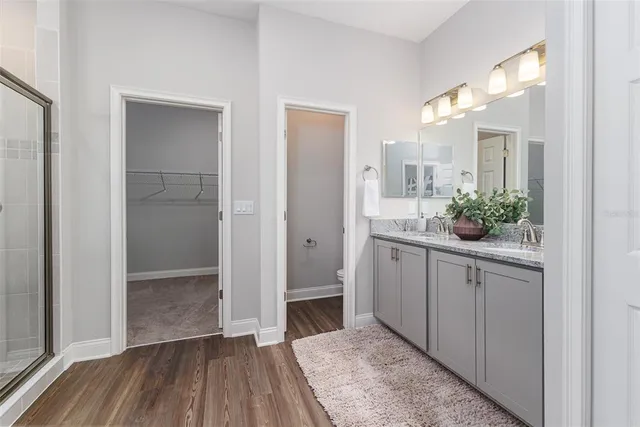 a bathroom with a granite countertop sink a toilet and shower
