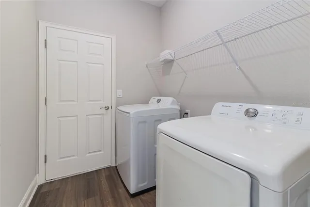 an empty room with a chandelier fan and windows
