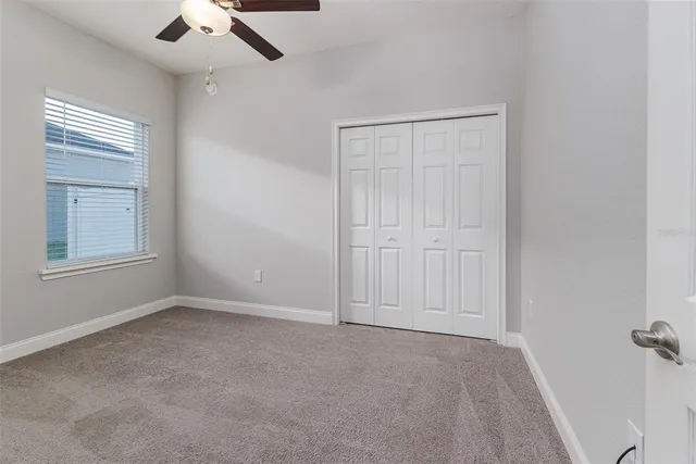 a view of a workspace room with furniture and window