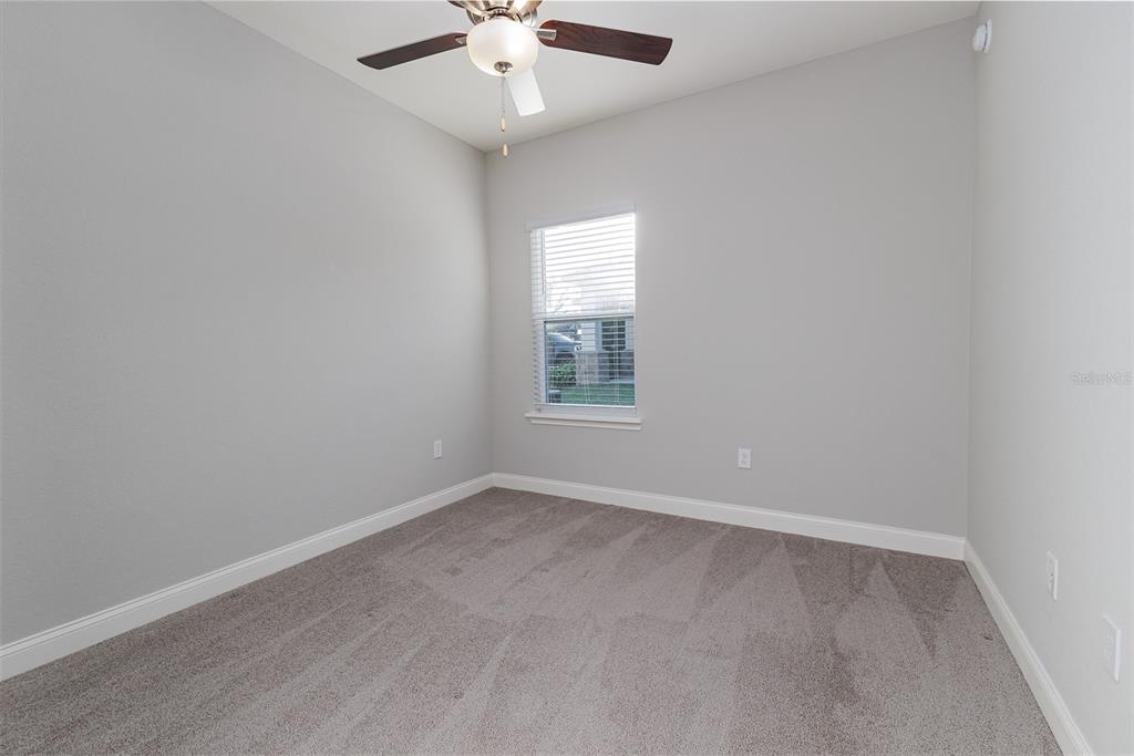 3150 Kendal Way Lakeland, FL 33813 - Photo 33 of 61 an empty room with a chandelier fan and windows