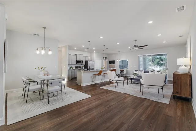 a living room with furniture dining table and wooden floor