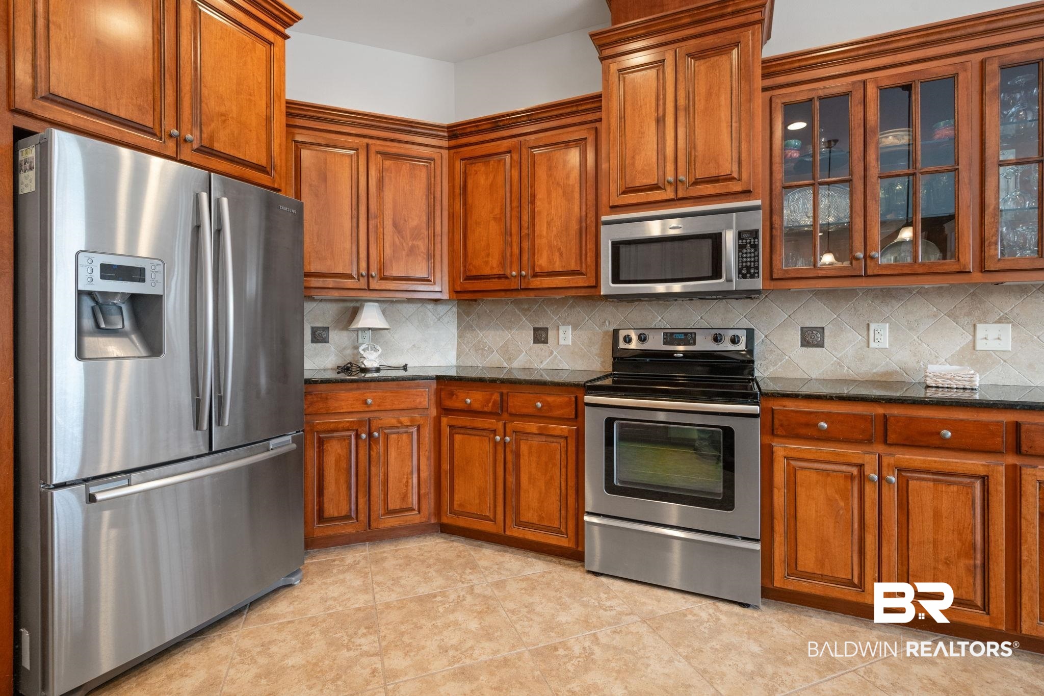 4771 Pecan Ridge East Mobile, AL 36619 - Photo 24 of 48 Kitchen featuring appliances with stainless steel finishes, brown cabinets, and glass insert cabinets
