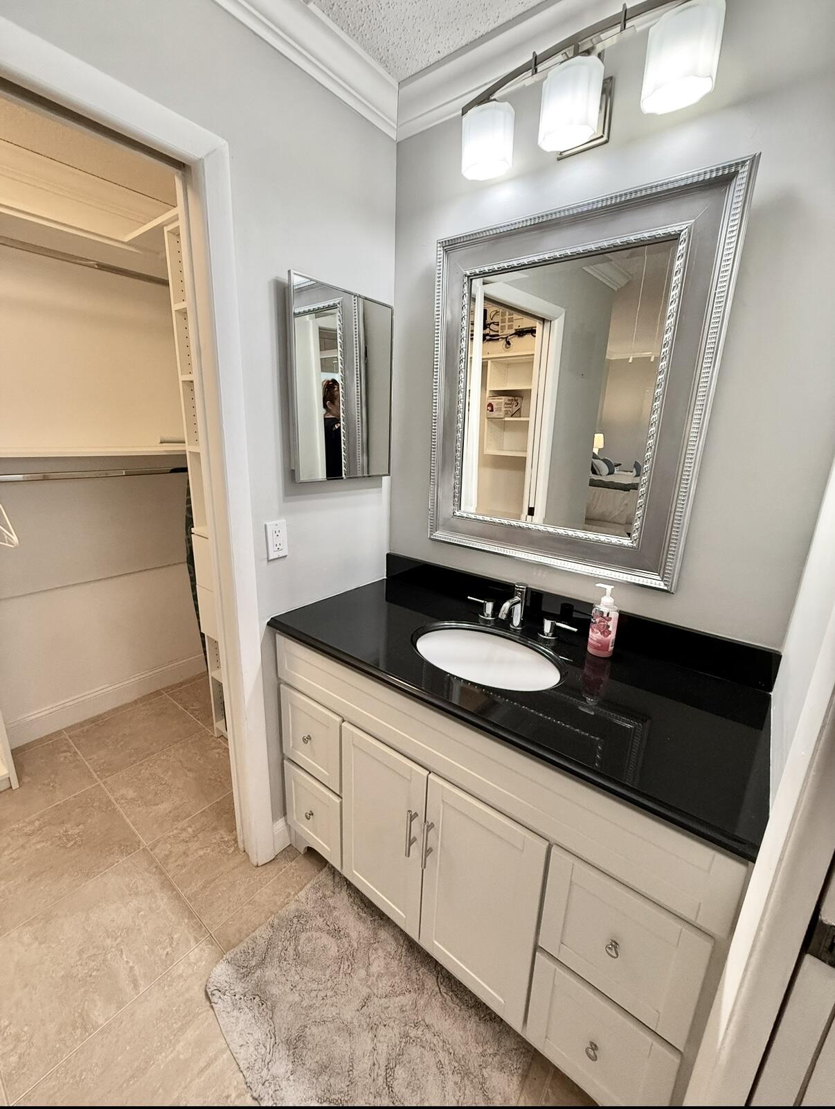 828 Timberview Drive, Unit D Fort Pierce, FL 34982 - Photo 17 of 28 a bathroom with a granite countertop sink and a mirror
