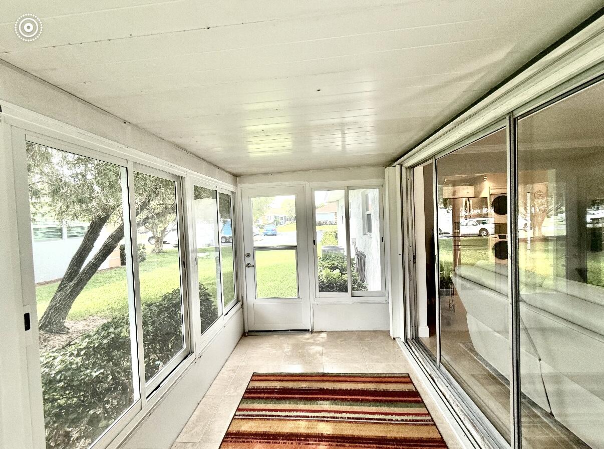 828 Timberview Drive, Unit D Fort Pierce, FL 34982 - Photo 20 of 28 a view of a large room with wooden floor and a glass door