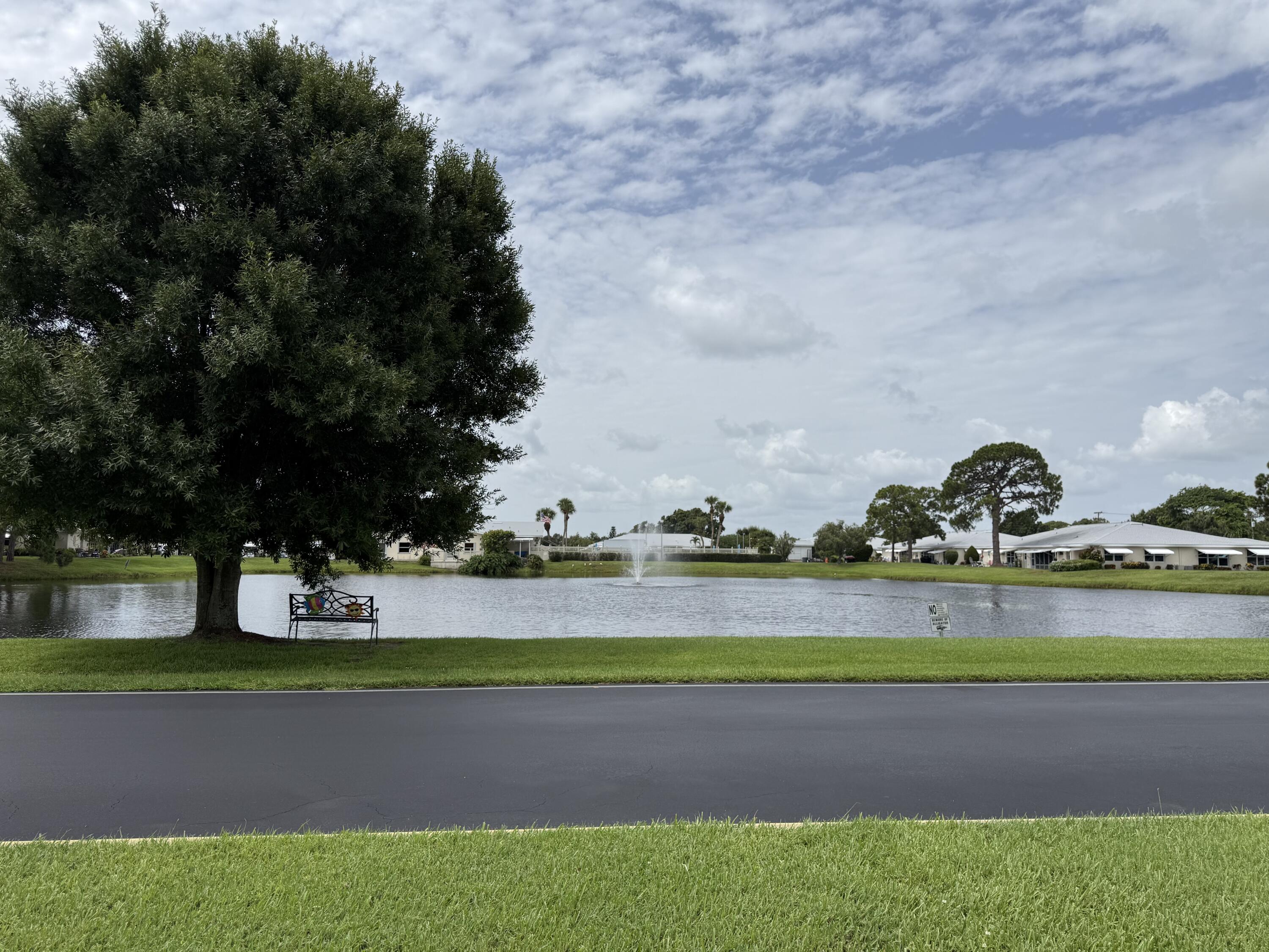 828 Timberview Drive, Unit D Fort Pierce, FL 34982 - Photo 27 of 28 a backyard of a house with lots of green space and fountain