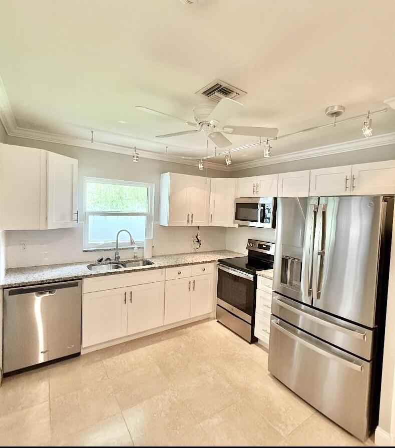 828 Timberview Drive, Unit D Fort Pierce, FL 34982 - Photo 4 of 28 a large kitchen with cabinets and stainless steel appliances