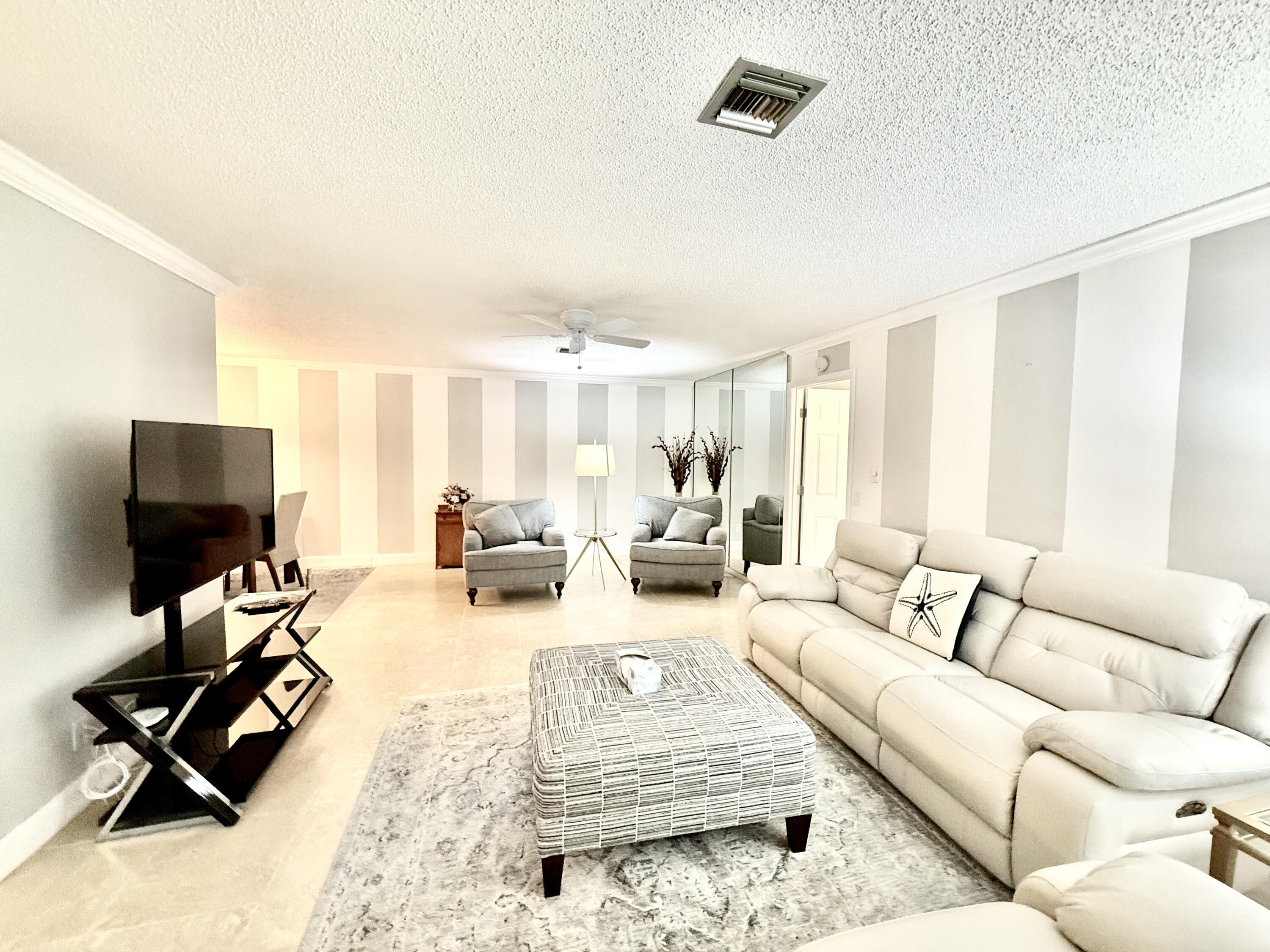828 Timberview Drive, Unit D Fort Pierce, FL 34982 - Photo 9 of 28 a living room with furniture wooden floor and a flat screen tv