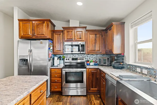 a kitchen with stainless steel appliances granite countertop a sink stove and refrigerator