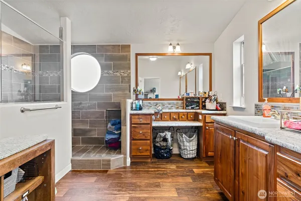 a large kitchen with stainless steel appliances granite countertop a sink and a wooden floors