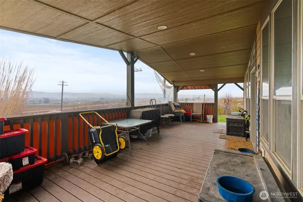 a view of a balcony with chairs and wooden floor