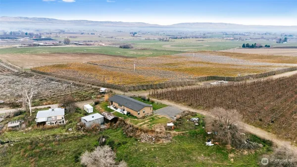 an aerial view of ocean and residential houses with outdoor space