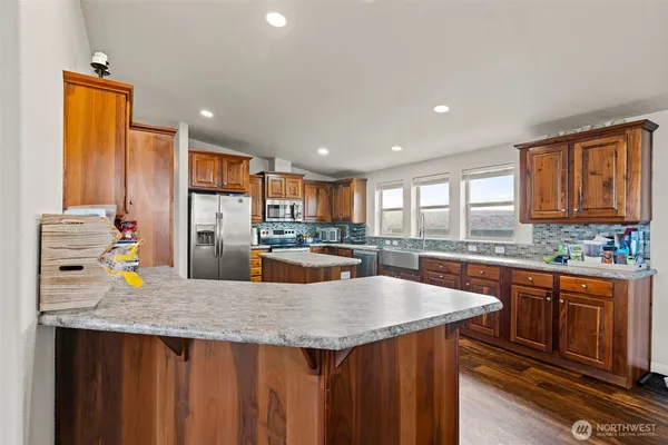 a kitchen with granite countertop a refrigerator a stove and a sink