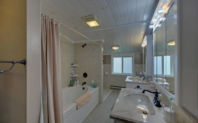 a bathroom with a tub a sink and mirrors