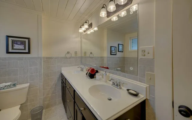 a bathroom with a sink a toilet and a mirror