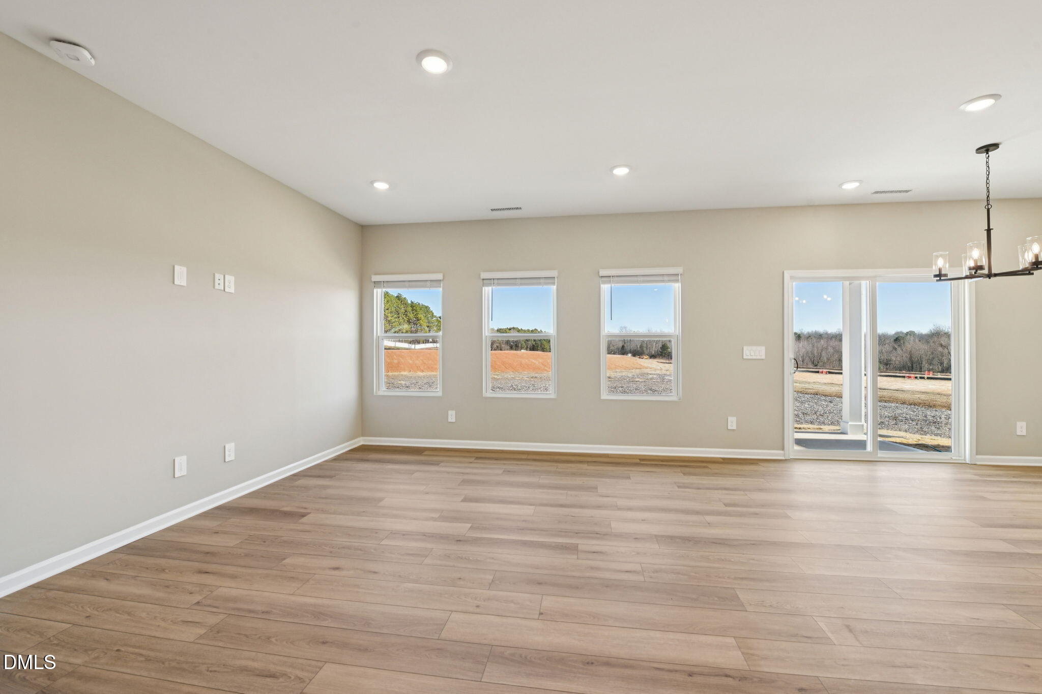 3516 Telluride Trail Raleigh, NC 27616 - Photo 12 of 47 a view of an empty room with wooden floor and windows