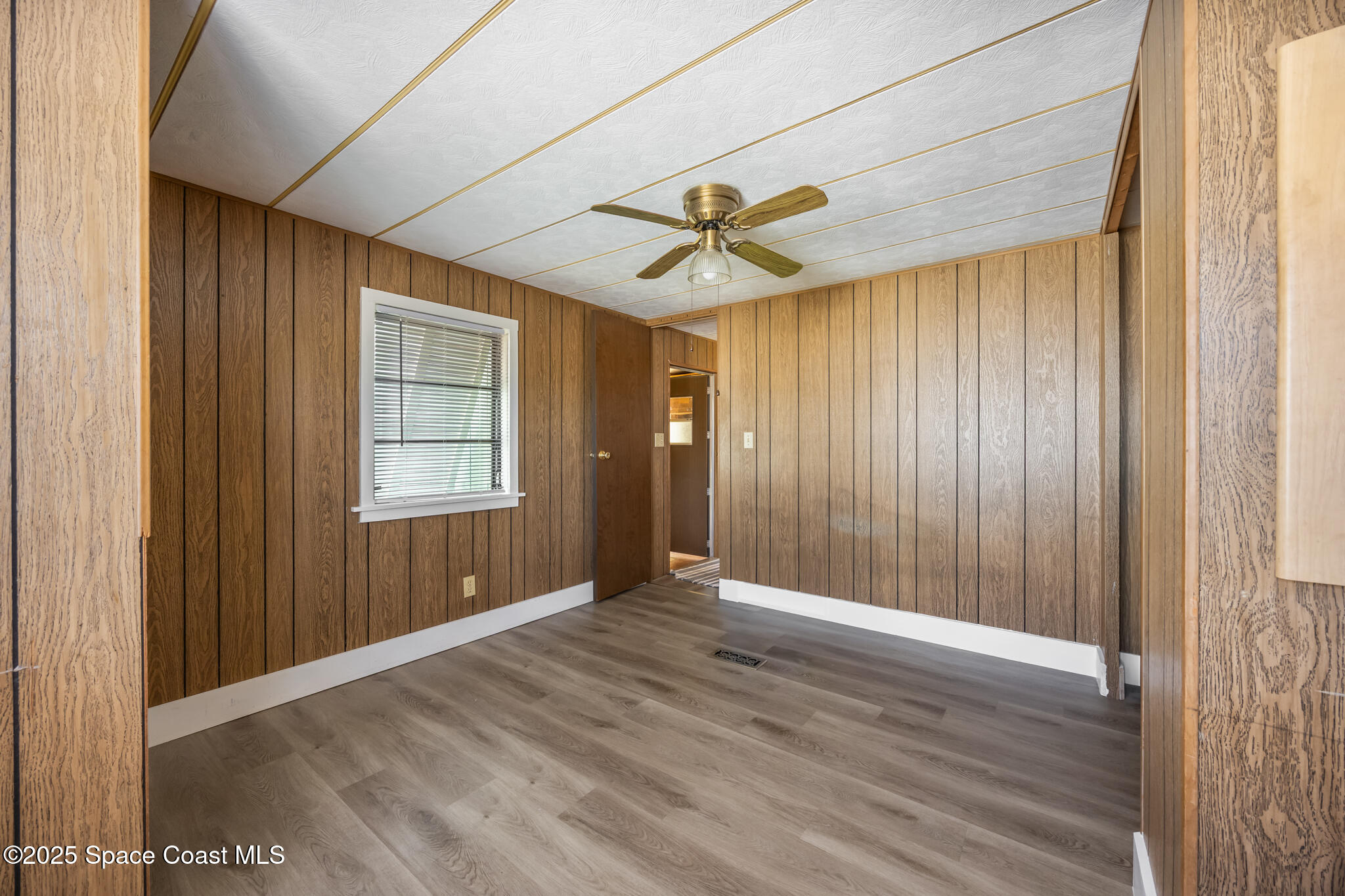 4895 Orange Street Mims, FL 32754 - Photo 12 of 33 an empty room with wooden floor and windows