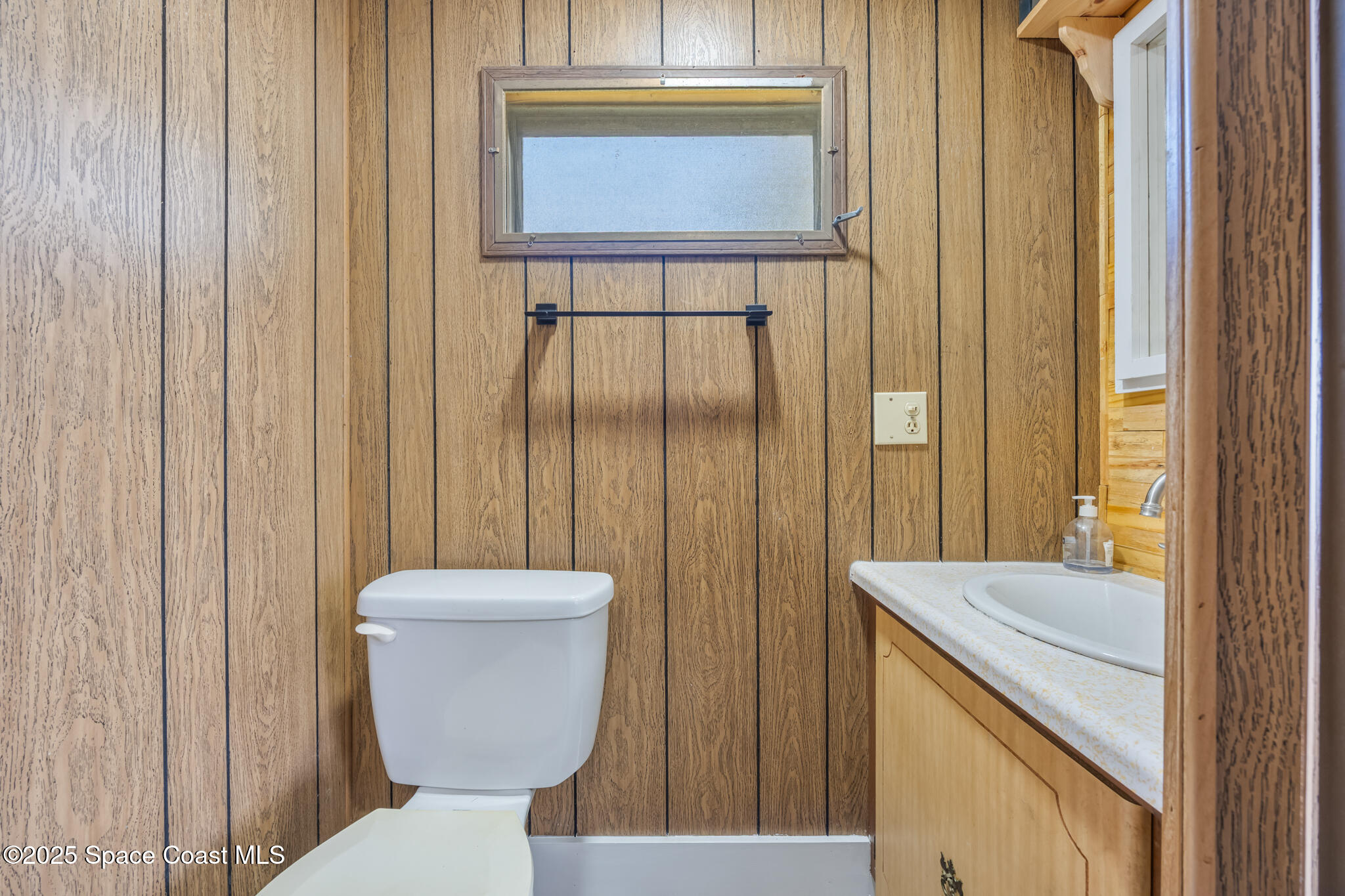 4895 Orange Street Mims, FL 32754 - Photo 16 of 33 a bathroom with a toilet a sink and mirror