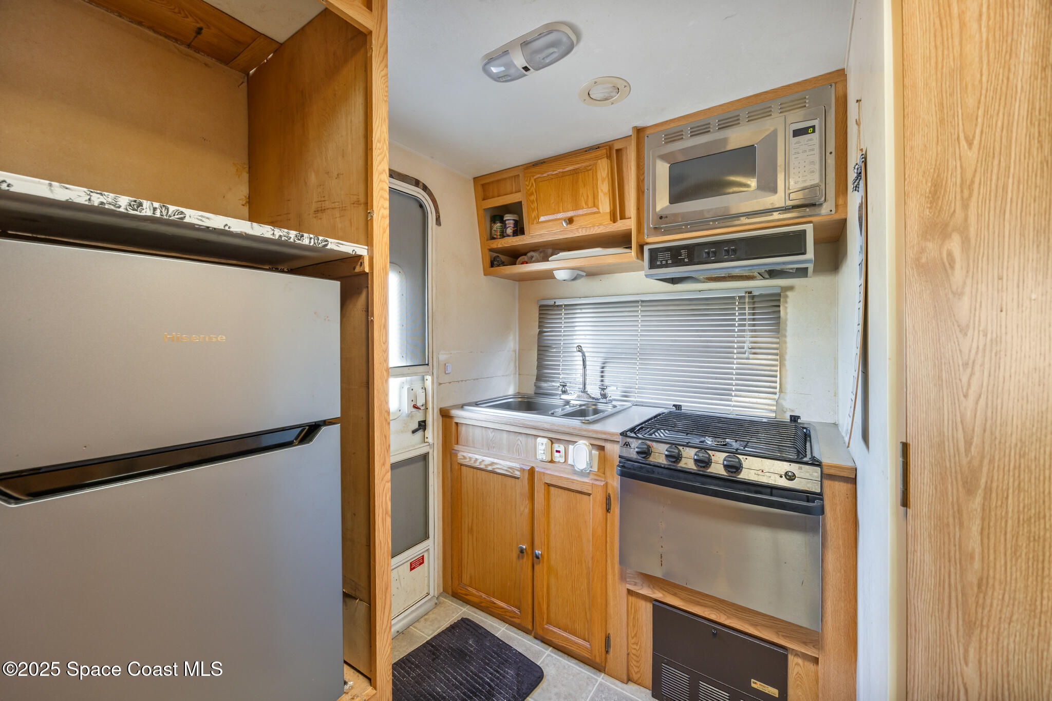 4895 Orange Street Mims, FL 32754 - Photo 25 of 33 a kitchen with stainless steel appliances granite countertop cabinets and a stove top oven