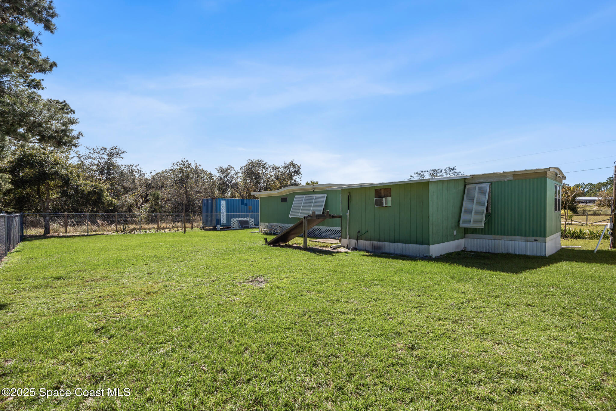 4895 Orange Street Mims, FL 32754 - Photo 3 of 33 a green field with some trees in the background