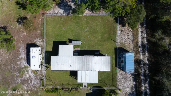 an aerial view of a house with a yard and large tree