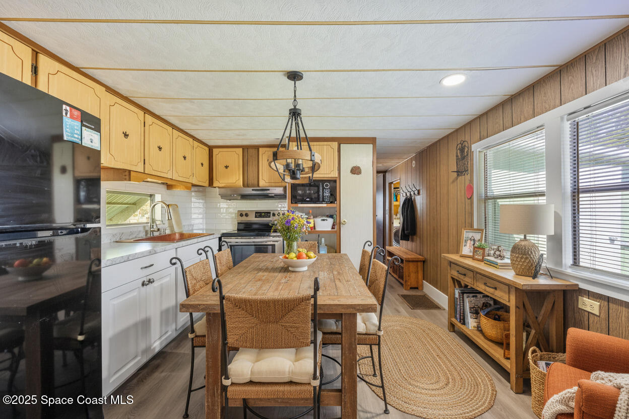 4895 Orange Street Mims, FL 32754 - Photo 6 of 33 a kitchen with stainless steel appliances kitchen island granite countertop a table chairs in it and wooden floors
