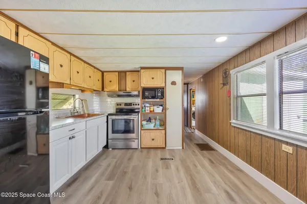 a kitchen with stainless steel appliances a refrigerator a stove top oven a sink dishwasher and wooden cabinets